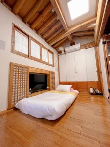 首尔Hwadong 1Beonji的大房间设有一张大床,拥有木制天花板