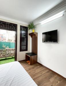 河内Hanoi Oriental Viewl Hotel的一间卧室配有一张床,墙上配有电视