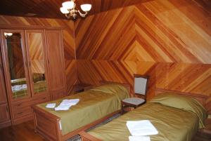 Protiv'yeZapovednye Ustja的一间带两张床铺的卧室,位于带木墙的房间内