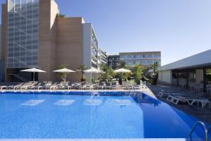 阿尔塔夫拉阿尔塔夫拉马尔酒店 的一个带椅子和遮阳伞的大型游泳池