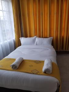 内罗毕7 Days Holiday Inn的一间卧室配有一张床,上面有两条毛巾