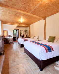 库斯科Spirit Of The River Lodge的配有木天花板的客房设有两张床。