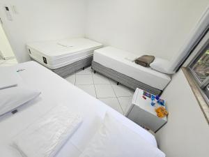 里约热内卢Quarto Privativo em Condominio的客房设有两张床和窗户。