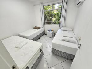 里约热内卢Quarto Privativo em Condominio的小房间设有两张床和窗户