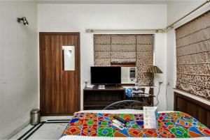 kolkataGoroomgo Ullash Residency Salt Lake City Kolkata - Luxurious Room Quality - Excellent Customer Service的一间卧室配有一张床和一台电视。