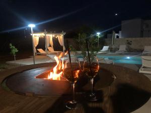 斯佩基亚B&B Casa Karina Pool&Rooms的两杯酒坐在火炉旁的桌子上