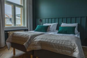 图尔库Ineon Hotel的一间卧室配有两张带绿色枕头的床