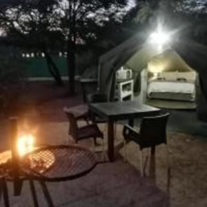 斯库库扎Yebo Safari,Glamping and Safaris的配有桌椅和床的帐篷