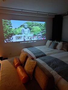 镰仓市Tre casa hotel KAMAKURA的配有大屏幕的客房内的两张床