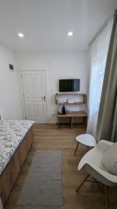 莫斯塔尔Aurelia Rooms的一间卧室配有一张床、一张沙发和一台电视。