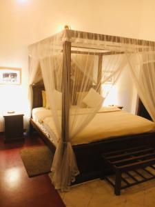 康提Colonial Residence Kandy的一间卧室配有一张带天蓬的床