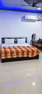 范兰德凡Priya Prem peeth guest house ⁰的一间卧室配有一张带橙色铺面毯子的床