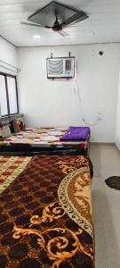 范兰德凡Priya Prem peeth guest house ⁰的墙上有地毯和空调的房间