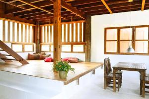 清迈resort hoshihana的一个带木桌和椅子的大客厅
