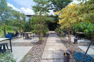 KlatenOYO 93885 D'harjo Guesthouse的花园设有桌椅和树木