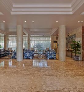 孟买Regent Hotel Andheri的大厅,在大楼里设有圆柱和沙发