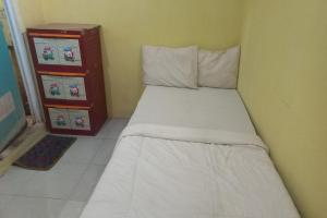 直葛SPOT ON 93886 Kost Zalfa Amalia Syariah的一间小卧室,配有白色的床和梳妆台