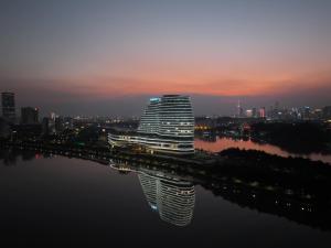 广州洲至奢选广州香岚官洲酒店的一座大建筑,在水中反射