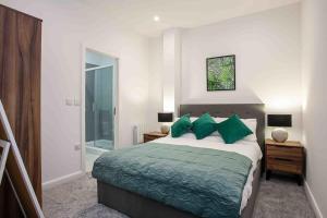 博尔顿Modern & Stylish 1 Bedroom Apartment in Bolton的一间卧室配有一张带绿色枕头的大床