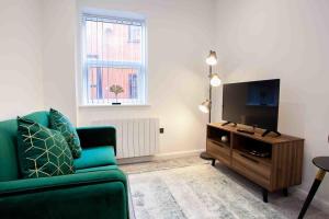 博尔顿Modern & Stylish 1 Bedroom Apartment in Bolton的客厅配有绿色沙发和平面电视