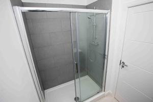 博尔顿Modern & Stylish 1 Bedroom Apartment in Bolton的浴室里设有玻璃门淋浴