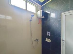 WatesRedDoorz Syariah Near Stasiun Wates的带淋浴喷头的浴室