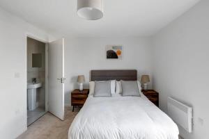利兹Spacious 1 Bedroom Apartment in a Converted Mill的白色卧室设有一张大床和一个水槽