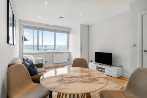 伊斯特雷格Central Eastleigh 1 Bedroom Apartment的客厅配有桌椅和电视。