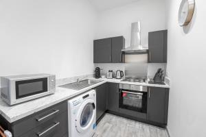 布赖尔利希尔Modern 1 Bedroom Apartment in Dudley的厨房配有微波炉和1台洗衣机。