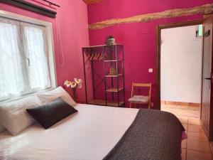 穆特里库ANTZOMENDI的一间卧室设有一张大床和粉红色的墙壁