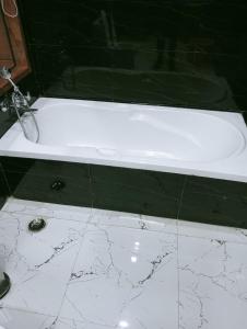 加济阿巴德wooden suits的浴室铺有大理石地板,配有白色浴缸。