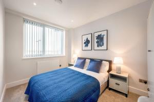 伊斯特雷格Cosy 1 Bedroom Apartment in the Heart of Eastleigh的一间卧室设有蓝色的床和窗户。