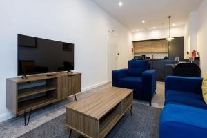 博尔顿Contemporary 1 Bed Apartment Central Bolton的客厅配有平面电视和蓝色椅子。