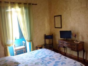 圣米格尔德阿沃纳埃斯昆纳斯4号乡村酒店的一间卧室配有一张床和一张书桌及电视