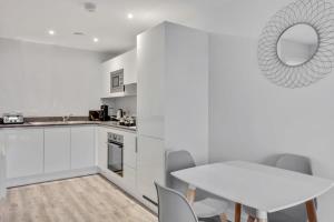 伯明翰Stunning 1br flat in Birmingham的白色的厨房配有白色的桌子和桌椅