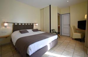 Viviers勒雷莱斯杜韦瓦莱斯酒店的一间卧室配有一张大床和一把椅子