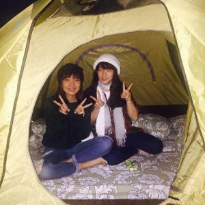 大叻Dalat Inn ez home的两个女孩坐在帐篷里,做和平的标志