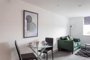 利兹Cosy & Modern 1 Bed Apartment Leeds的客厅配有玻璃桌和沙发