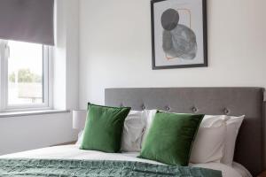利兹Cosy & Modern 1 Bed Apartment Leeds的一间卧室配有带绿色和白色枕头的床
