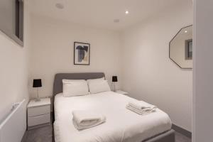 利兹Fantastic 1 Bedroom Apartment Leeds的白色卧室,配有带毛巾的床