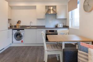 阿什福德Contemporary 1 Bedroom Apartment in Ashford的厨房配有桌子、水槽和洗衣机。