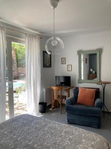 滨海萨纳里Maison d hôtes LA VILLA MADELEINE的一间卧室配有一张床、一把椅子和一张桌子