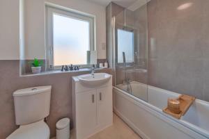 阿什福德Modern 1 Bedroom Apartment in Ashford的浴室配有卫生间、盥洗盆和浴缸。