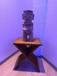 帕皮提Ononui Airport Studio的木桌上方的雕像