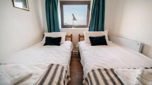 布德Lovely 2 Bedroom Coastal Cottage near Bude的带窗户的客房内设有两张单人床。