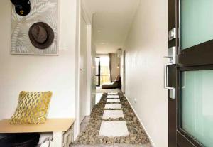 汉密尔顿Waikato Uni guest room with private bathroom的房屋内带有石地板的走廊