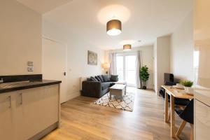 克劳利Fantastic 1 Bed Apartment in Crawley的厨房以及带沙发和桌子的客厅。