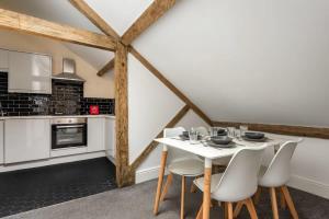 唐克斯特Budget Studio Apartment in Central Doncaster的厨房以及带白色桌椅的用餐室。