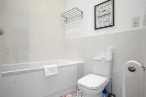 沃金Contemporary 1 Bedroom Apartment in Central Woking的白色的浴室设有卫生间和浴缸。