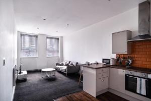 布莱克本Lovely 1 Bed Apartment in Central Blackburn的厨房以及带沙发和桌子的客厅。